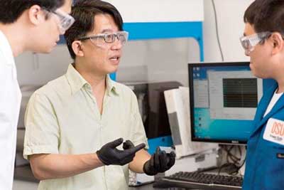 Chih-hung Chang and graduate student Zhongwei Gao discuss the specs for a new type of nanomaterial printer