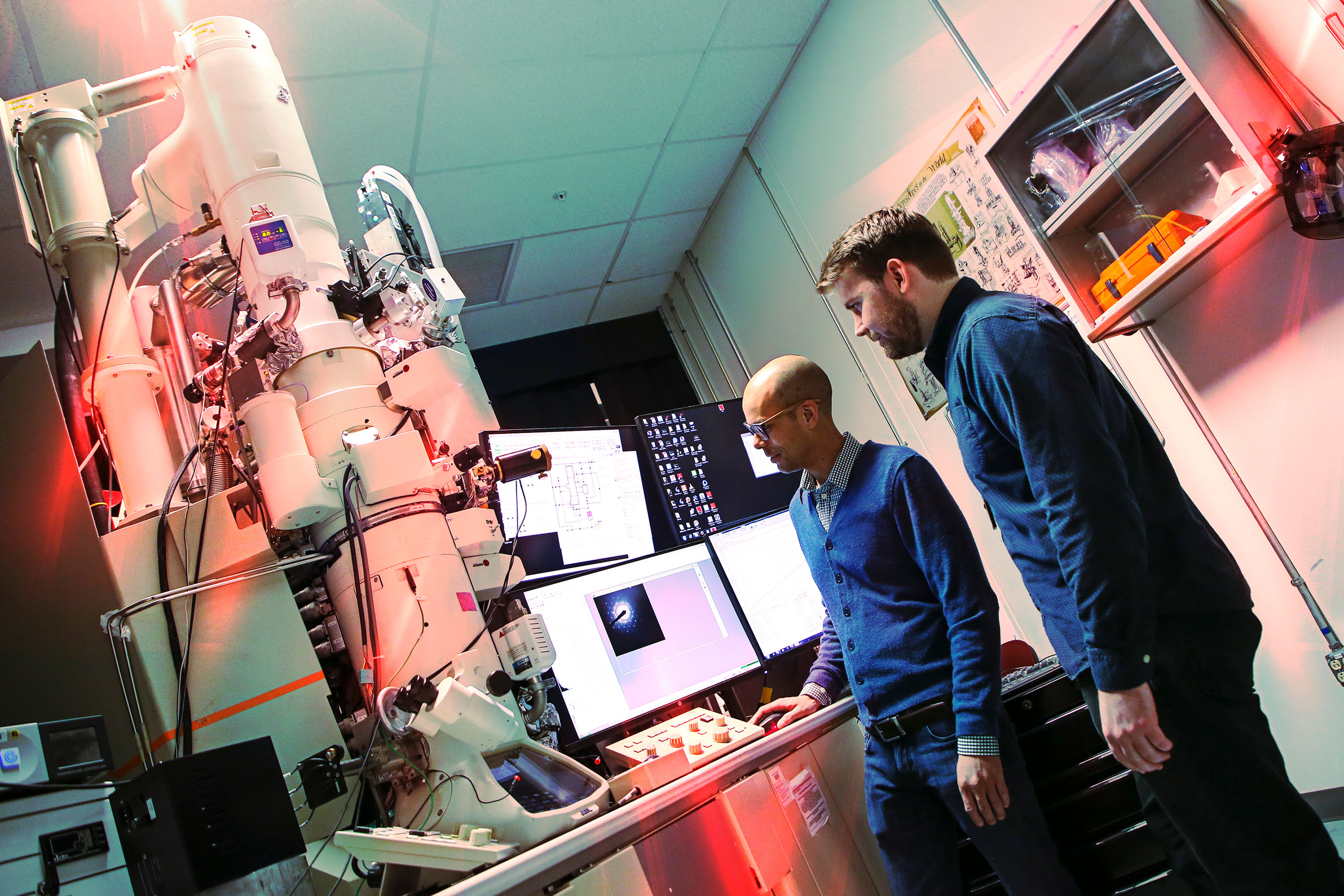 Christopher Barr, right, a former Sandia National Laboratories postdoctoral researcher, and University of California, Irvine, professor Shen Dillon operate the In-situ Ion Irradiation Transmission Electron Microscope